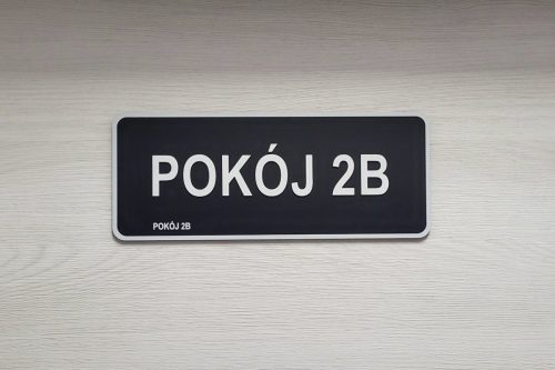 Tabliczka z kontrastową, wypukłą czcionką, białą na czarnym tle